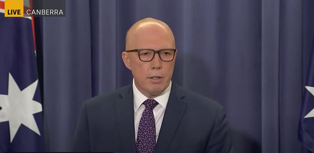 Peter Dutton in front of a blue wall. 